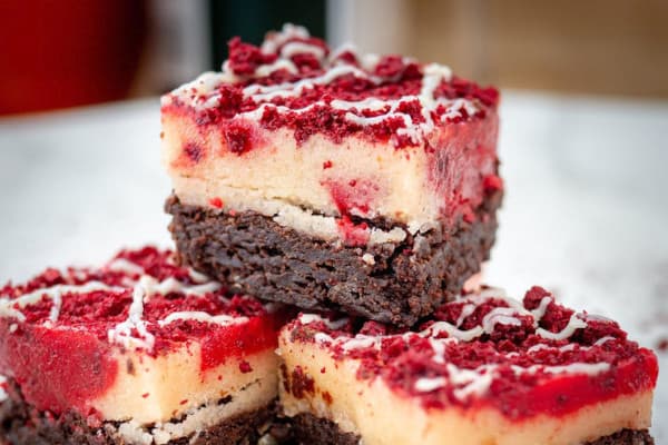 Three brownies stack on top of each other with a red topping
