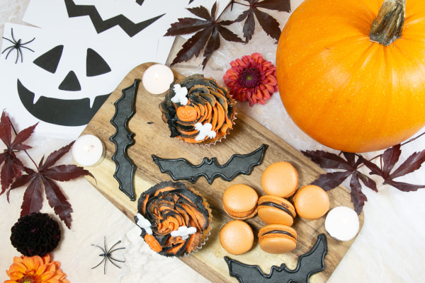 Halloween-themed treats on a wooden board with a pumpkin