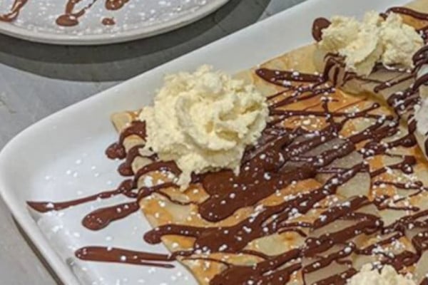 Crepe with chocolate sauce on a white plate