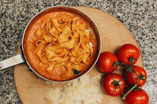 Saucepan full of pasta and tomato sauce