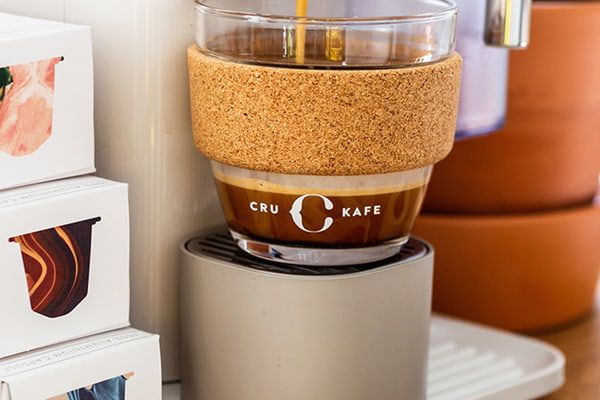 Coffee machine making coffee into a glass reusable coffee cup