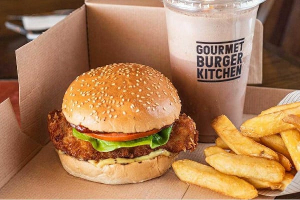 Chicken burger, fries and a milkshake in a cardboard takeaway container