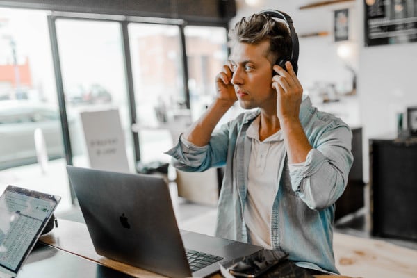 Man with headphones on in front of laptop