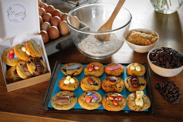 Decorated cookies on a baking tray surrounded by ingredients