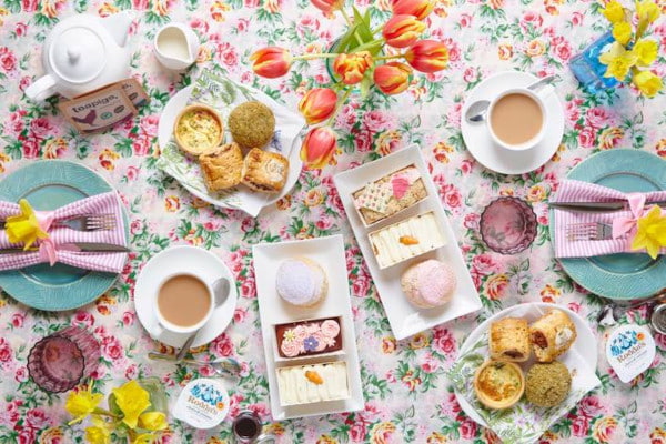 Afternoon tea items on a floral picnic blanket