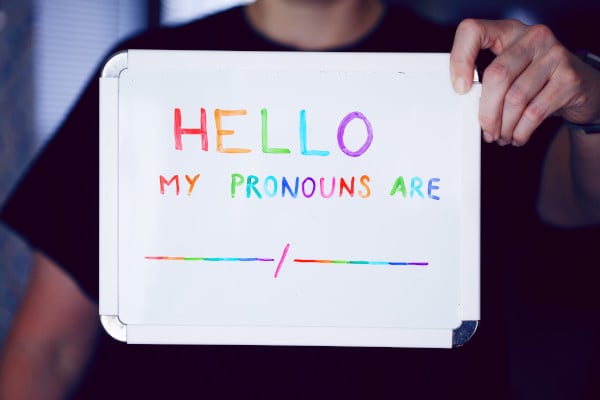 Person holding up sign saying 'hello my pronouns are'