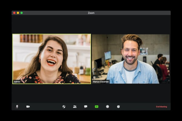 Two people on a Zoom call smiling