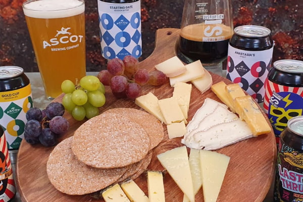 Cheese board with cans of craft beer