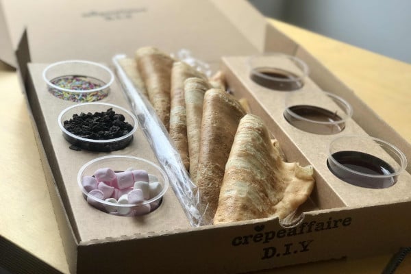 Cardboard box filled with crepes and toppings