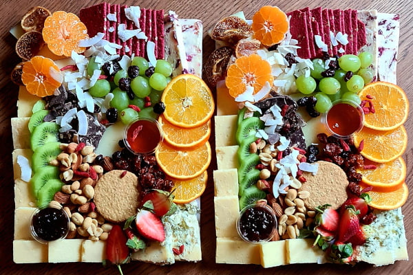 Platter full of cheeses, fruits, and crackers