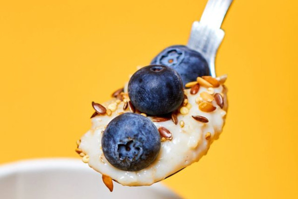 Spoonful of porridge with blueberries on top