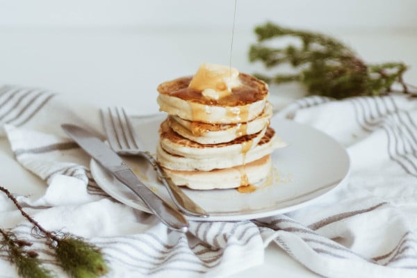 Stack of fluffy pancakes with drizzle of sauce