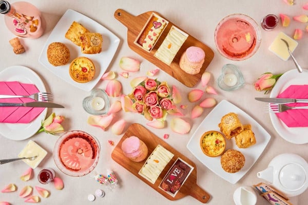 a spread of valentine's themed food items including cake and pastries